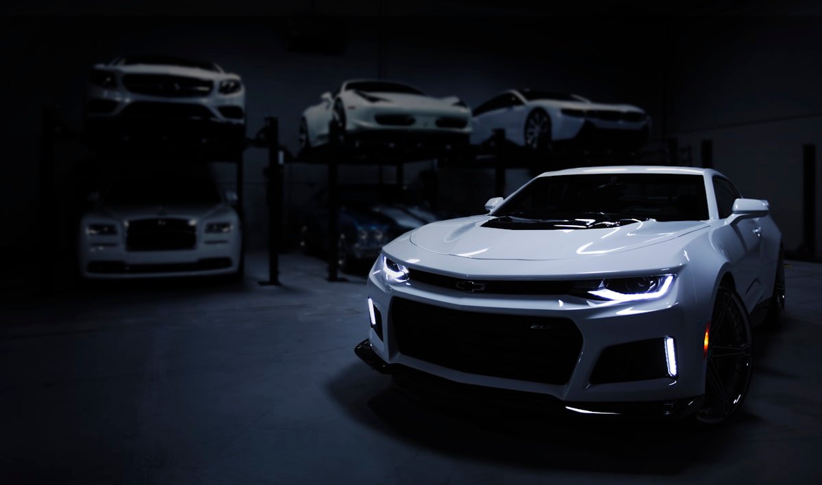 Front bumper and grille area of a performance vehicle in a dark automotive facility